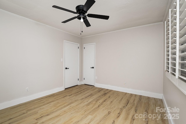 empty room with ornamental molding, baseboards, and wood finished floors