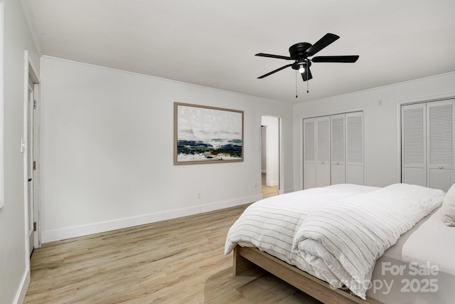 bedroom featuring multiple closets, light wood finished floors, ceiling fan, and baseboards