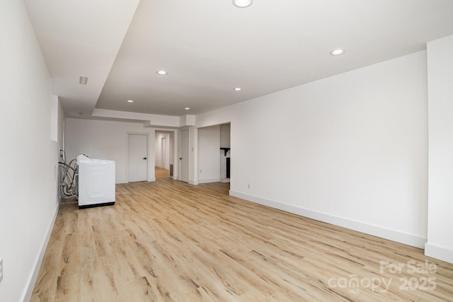 empty room with light wood-style floors, recessed lighting, baseboards, and washer / dryer