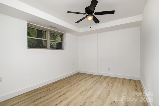 empty room featuring visible vents, baseboards, a ceiling fan, and wood finished floors