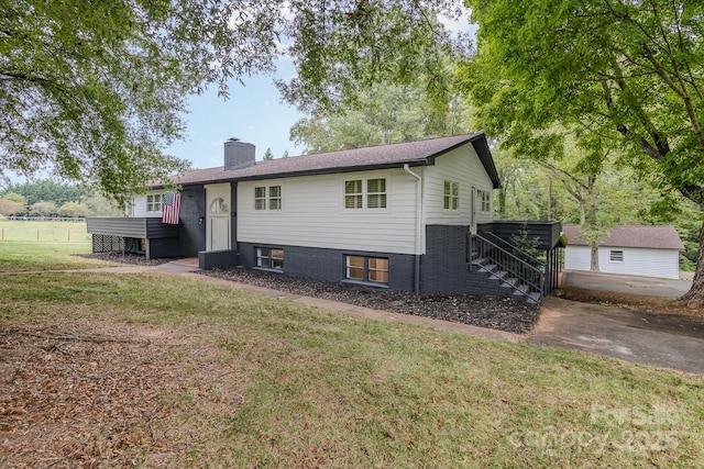 bi-level home featuring a chimney, a front yard, and stairway