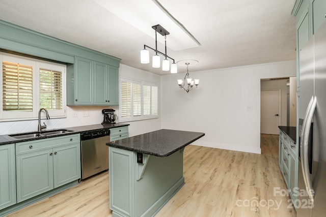 kitchen with light wood-type flooring, appliances with stainless steel finishes, a sink, and green cabinetry