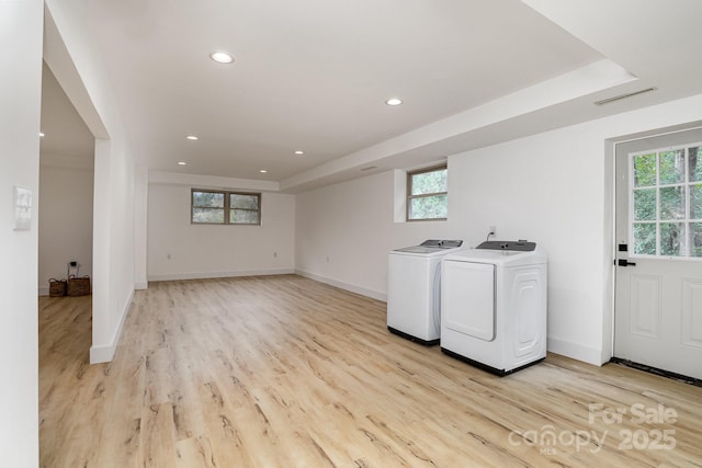laundry area featuring washer and dryer, light wood-style floors, and a healthy amount of sunlight