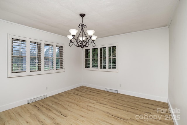 unfurnished room featuring a chandelier, visible vents, baseboards, and wood finished floors