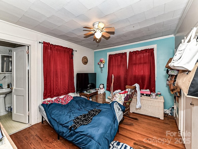 bedroom with hardwood / wood-style flooring, ceiling fan, and ornamental molding