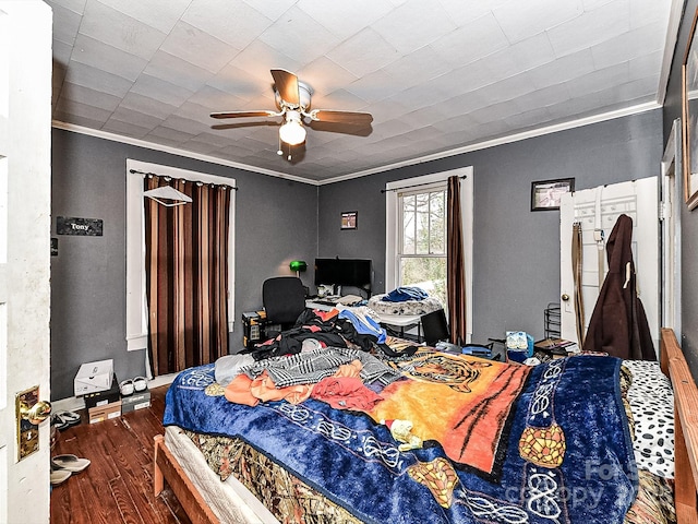 bedroom featuring ceiling fan, ornamental molding, and wood-type flooring