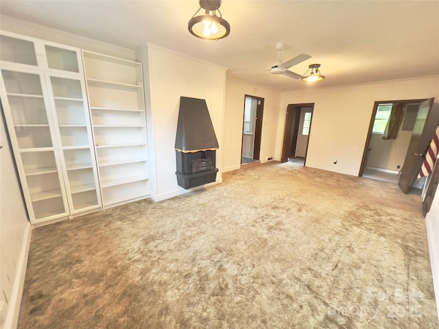 108 Meadowview Pl, Lenoir, NC 28645 - unfurnished living room featuring carpet flooring, a wood stove, baseboards, a ceiling fan, and ornamental molding