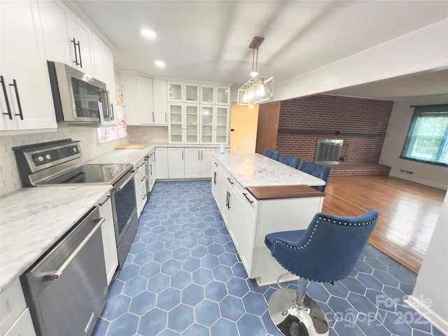 108 Meadowview Pl, Lenoir, NC 28645 - kitchen with appliances with stainless steel finishes, open floor plan, white cabinetry, glass insert cabinets, and a center island