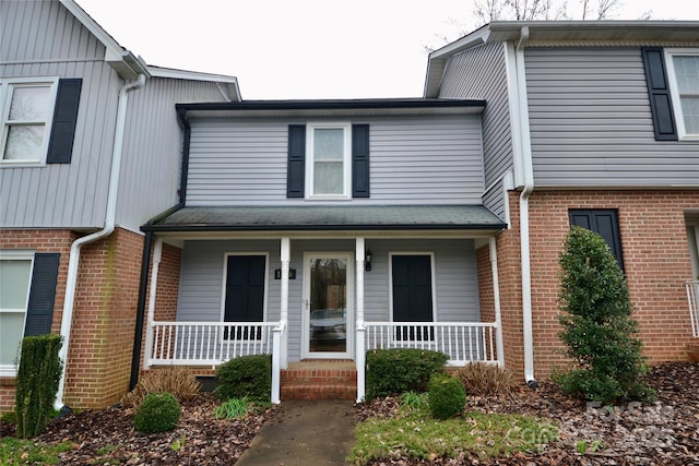 multi unit property featuring covered porch and brick siding