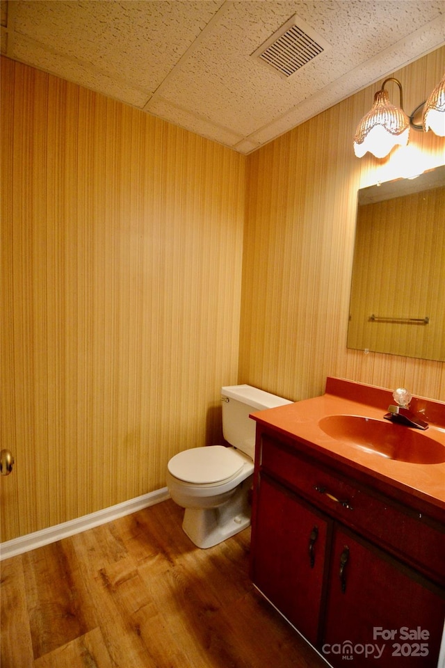 bathroom with hardwood / wood-style flooring, vanity, and toilet