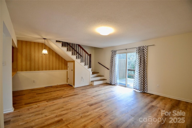 unfurnished room featuring wood-type flooring and a textured ceiling