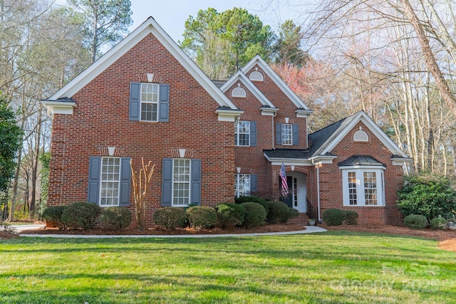 view of front of home featuring a front yard and brick siding