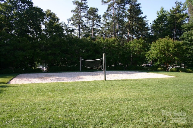 view of community with a lawn and volleyball court