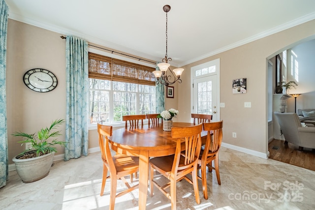 dining space featuring arched walkways, crown molding, and baseboards