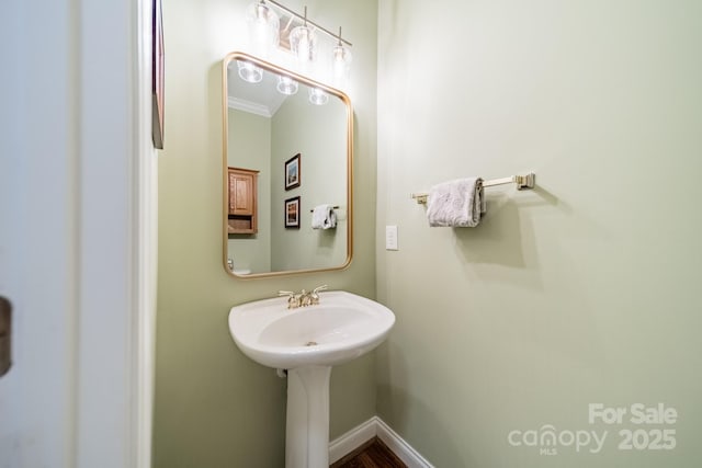 bathroom with ornamental molding and baseboards