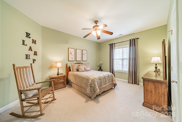 bedroom featuring light carpet, baseboards, and a ceiling fan