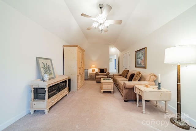 living area with baseboards, vaulted ceiling, a ceiling fan, and light colored carpet