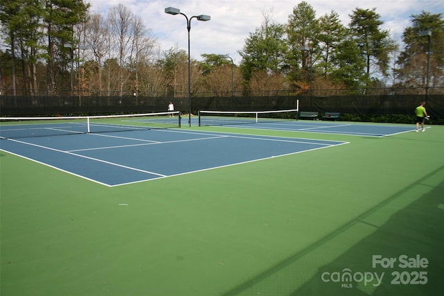 view of tennis court featuring fence