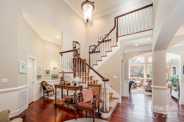 entryway with a high ceiling, crown molding, and dark hardwood / wood-style floors