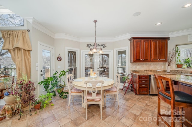 dining area featuring a notable chandelier, crown molding, and a wealth of natural light