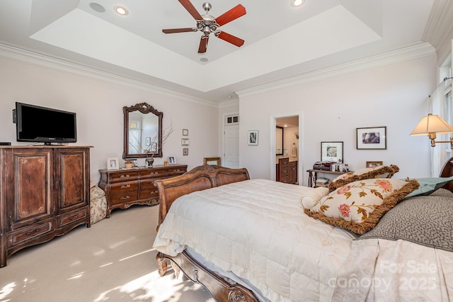 bedroom featuring crown molding, ensuite bathroom, carpet flooring, and a raised ceiling