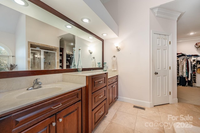 bathroom featuring vanity, ornamental molding, an enclosed shower, and tile patterned flooring