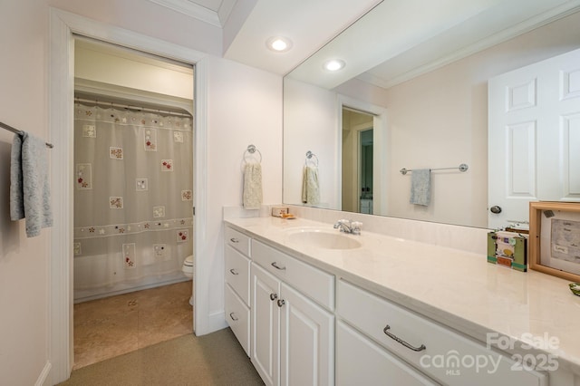 bathroom featuring ornamental molding, vanity, and toilet