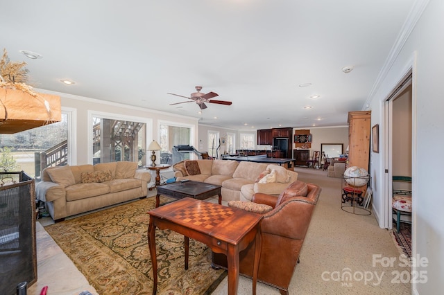 living room featuring a healthy amount of sunlight, ceiling fan, and ornamental molding