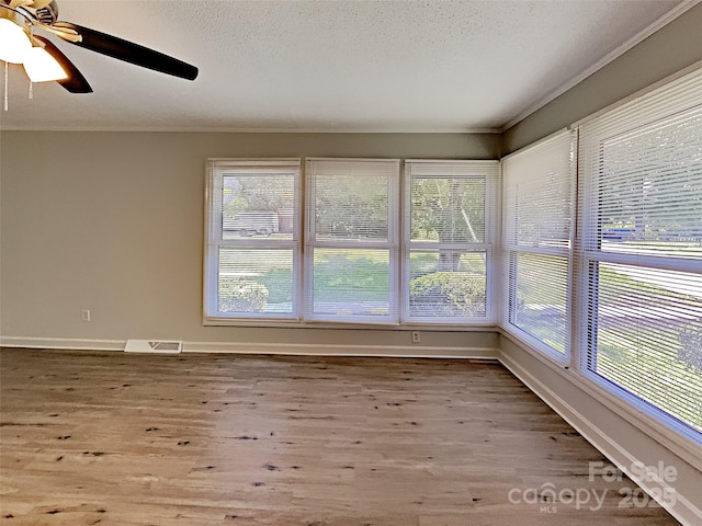 unfurnished sunroom with ceiling fan