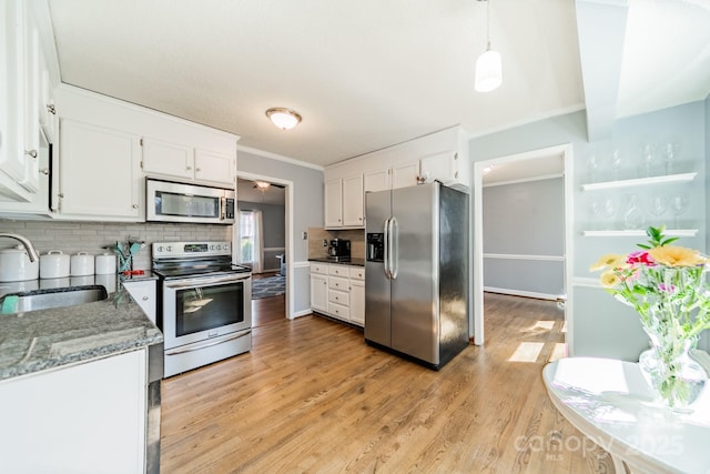 kitchen with white cabinets, light wood-style floors, stainless steel appliances, and a sink