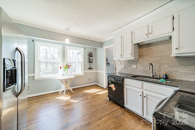 kitchen featuring light wood-style flooring, dark stone countertops, black appliances, white cabinetry, and a sink