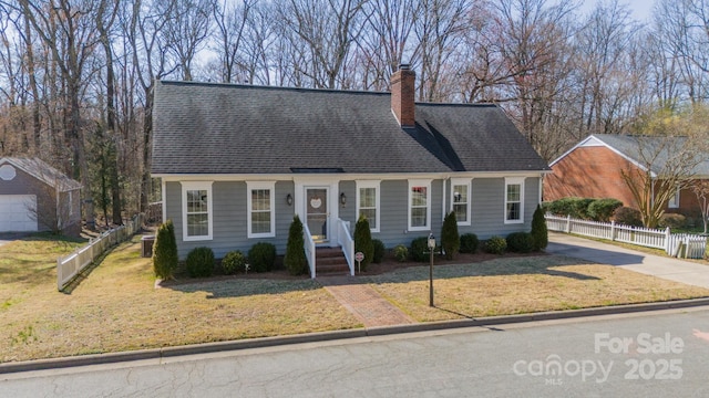 new england style home with a shingled roof, a chimney, fence, and a front lawn