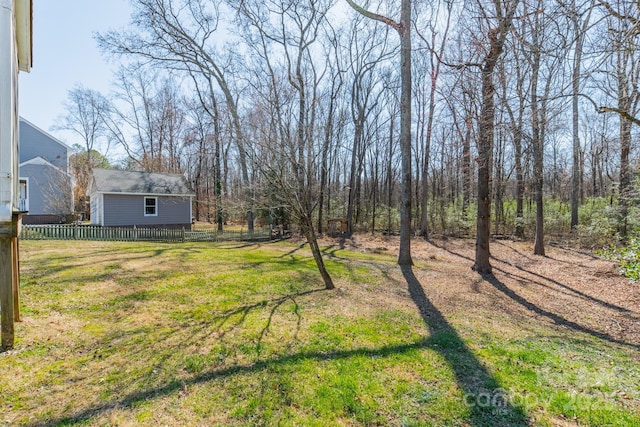 view of yard with fence and an outbuilding