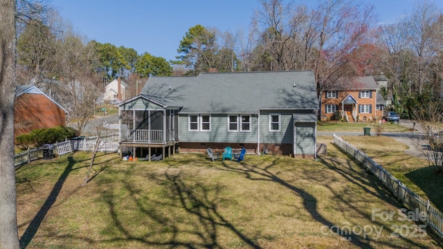 back of house featuring a yard, a chimney, a fenced backyard, and a sunroom