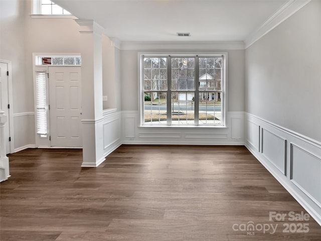 foyer entrance with dark wood-style floors, visible vents, plenty of natural light, and ornamental molding