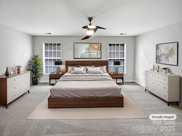 bedroom featuring a ceiling fan, visible vents, light carpet, and baseboards