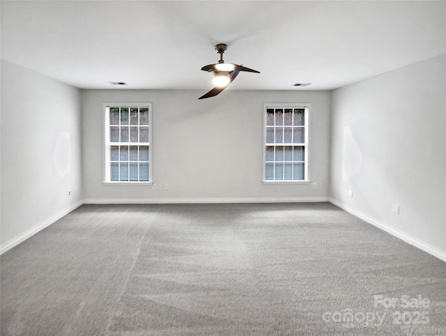 empty room with ceiling fan, carpet, visible vents, and baseboards