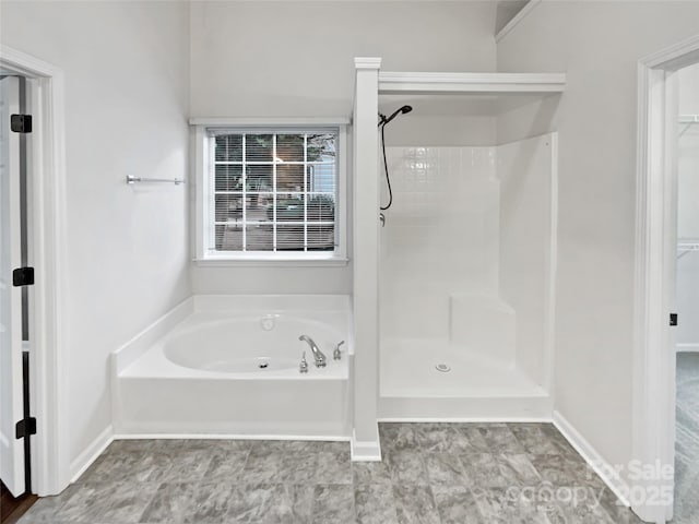 full bathroom featuring a garden tub, a shower stall, and a spacious closet