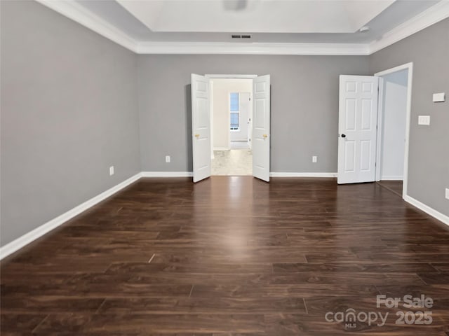 unfurnished bedroom featuring dark wood-style floors, ornamental molding, visible vents, and baseboards