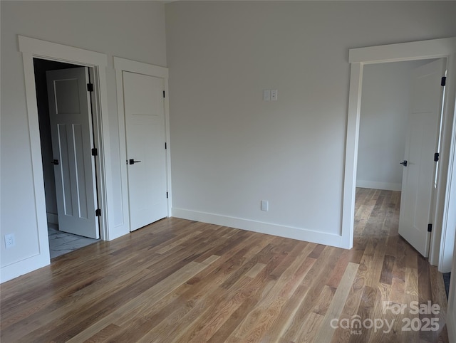 unfurnished bedroom with baseboards and light wood-style floors