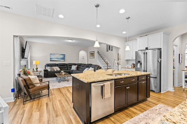 kitchen featuring appliances with stainless steel finishes, arched walkways, visible vents, and a sink