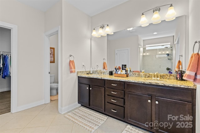 bathroom featuring double vanity, a stall shower, a sink, and tile patterned floors