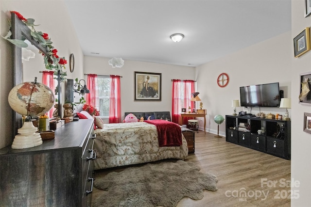 bedroom with wood finished floors and baseboards