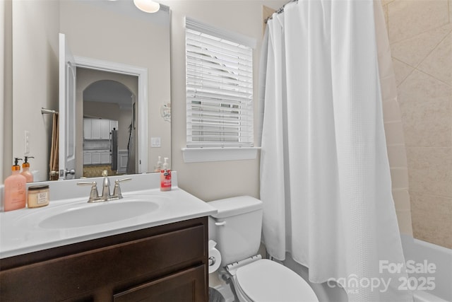 bathroom featuring toilet, shower / bathtub combination with curtain, and vanity