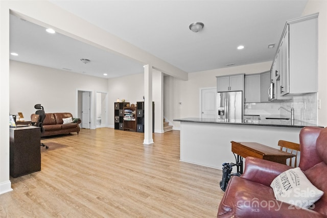 living area with baseboards, stairway, recessed lighting, and light wood-style floors