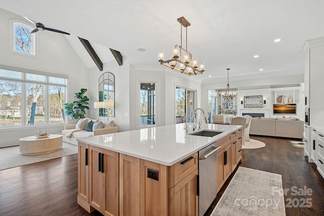 kitchen featuring light countertops, stainless steel dishwasher, open floor plan, white cabinets, and an island with sink