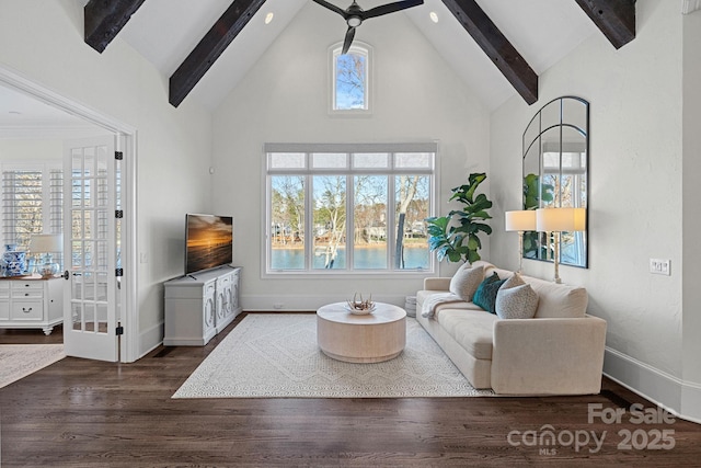 living area with a wealth of natural light, beam ceiling, dark wood finished floors, and ceiling fan