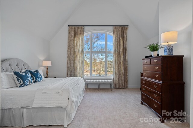 bedroom featuring vaulted ceiling and light colored carpet