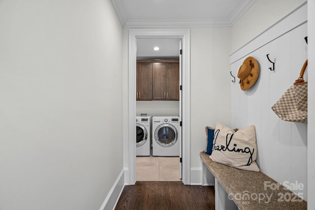 laundry area with cabinet space, baseboards, ornamental molding, dark wood-style flooring, and washing machine and dryer