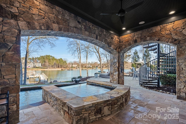 pool with a ceiling fan, stairway, an in ground hot tub, a water view, and a patio area